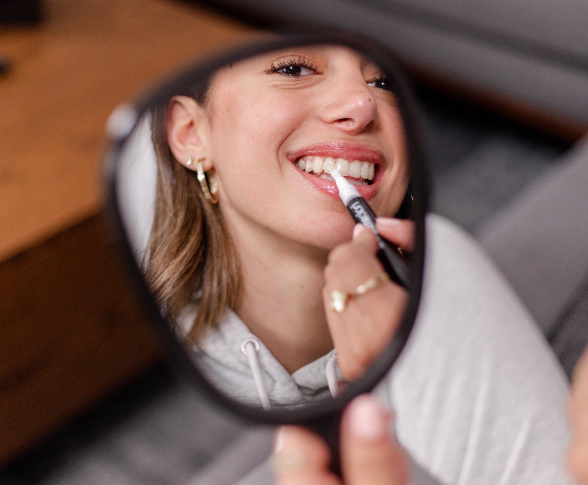 image of girl applying quick touch ups with her teeth whitening pen
